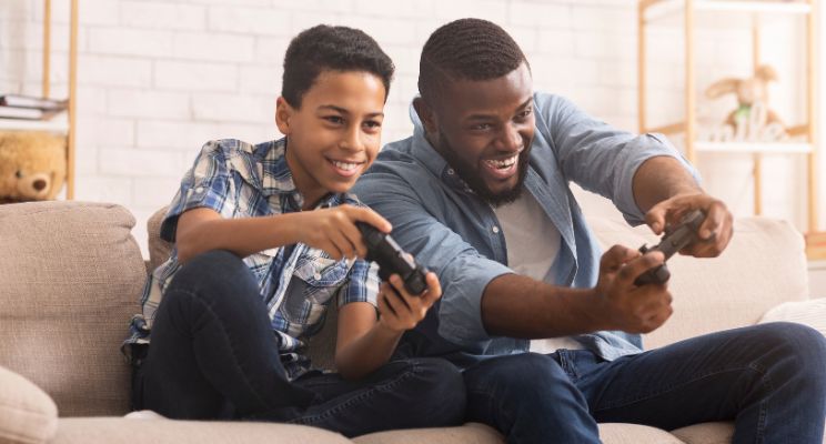 Father and son playing video games on the couch