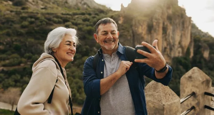 Older couple taking a selfie on a mountain trail